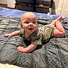 Bentley joined the competition — help win amazing prizes! baby, infant, camouflage_clothing, blanket, bed, smiling, face, blue_eyes, skin, person, cute, lying_down, indoors, toddler, happy, child, soft_texture, photography, portrait, young