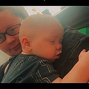 Bentley is registered to the contest to win money with this photo: baby, sleeping, adult, glasses, face, closeup, holding, portrait, tender, cozy, indoor, person, child, love, affection, head, skin, clothing, peaceful, resting