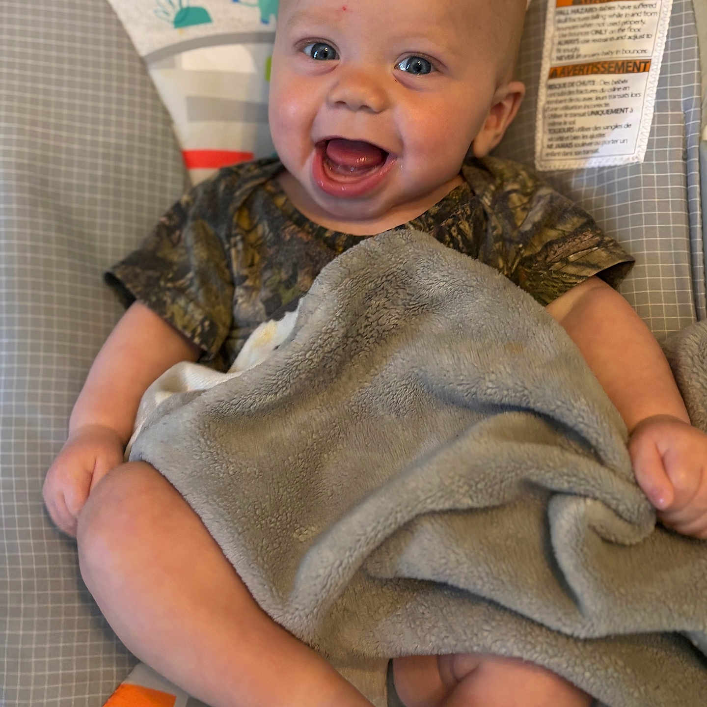 Bentley is registered to the contest to win money with this photo: baby, smiling, blanket, infant, child, happy, face, sitting, indoors, clothing, seat, pattern, colorful, cute, skin, foot, hand, portrait, cozy, expression