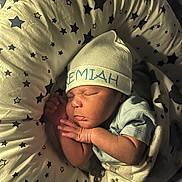 Jeremiah is registered to the contest to win money with this photo: newborn, baby, sleeping, hat, cap, star_pattern, cushion, infant, cozy, blanket, soft_lighting, resting, child, cute, peaceful, portrait, indoors, person, wrapped, sleep