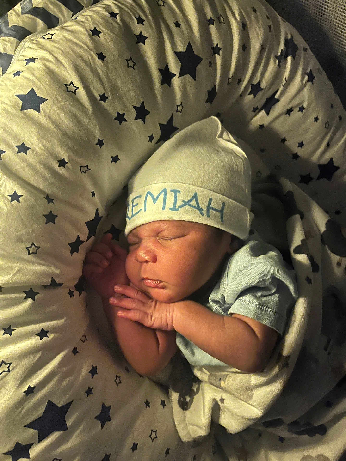 Jeremiah is registered to the contest to win money with this photo: newborn, baby, sleeping, hat, cap, star_pattern, cushion, infant, cozy, blanket, soft_lighting, resting, child, cute, peaceful, portrait, indoors, person, wrapped, sleep