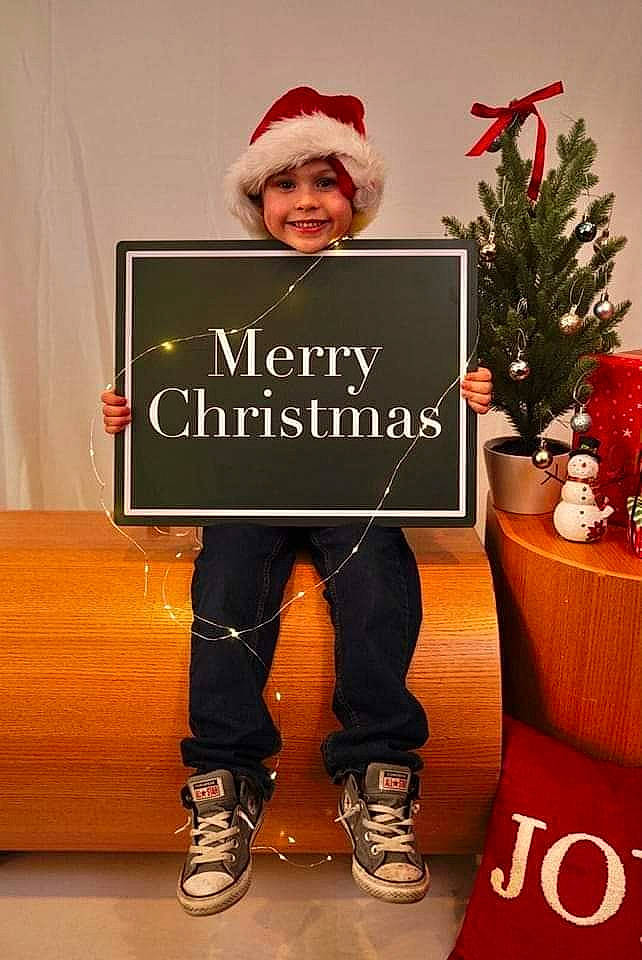 Ethan joined the competition — help win amazing prizes! christmas, christmas_decoration, christmas_eve, christmas_ornament, christmas_tree, event, facial_hair, font, footwear, happy, headwear, holiday, holiday_ornament, joy, knee, ornament, person, plant, red, sleeve