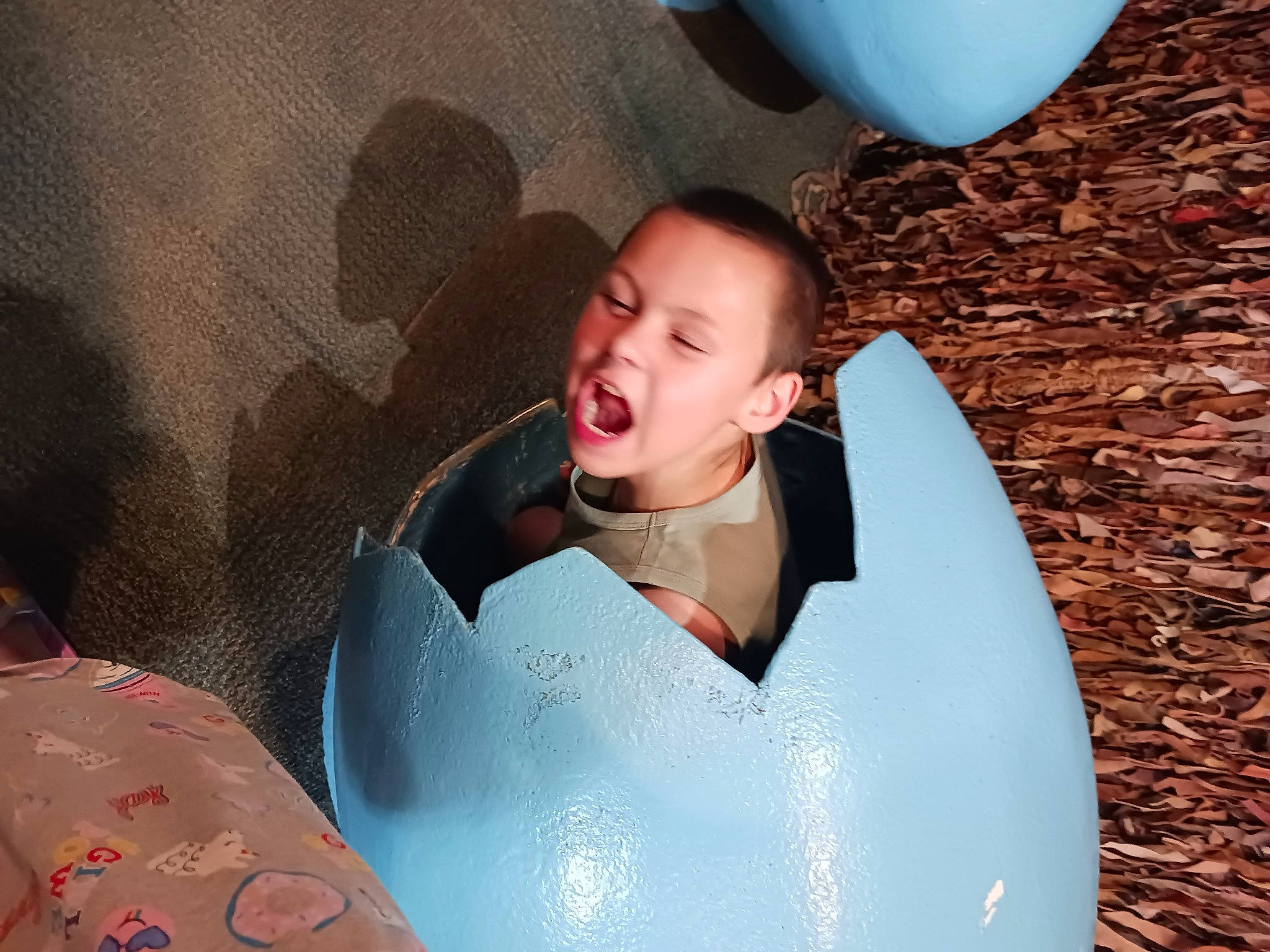 Ethan is registered to the contest to win money with this photo: baby, carmine, child, comfort, eye, facial_expression, fun, hair, hairstyle, happy, head, leisure, mouth, person, personal_protective_equipment, recreation, sitting, surfboard, t_shirt, toddler