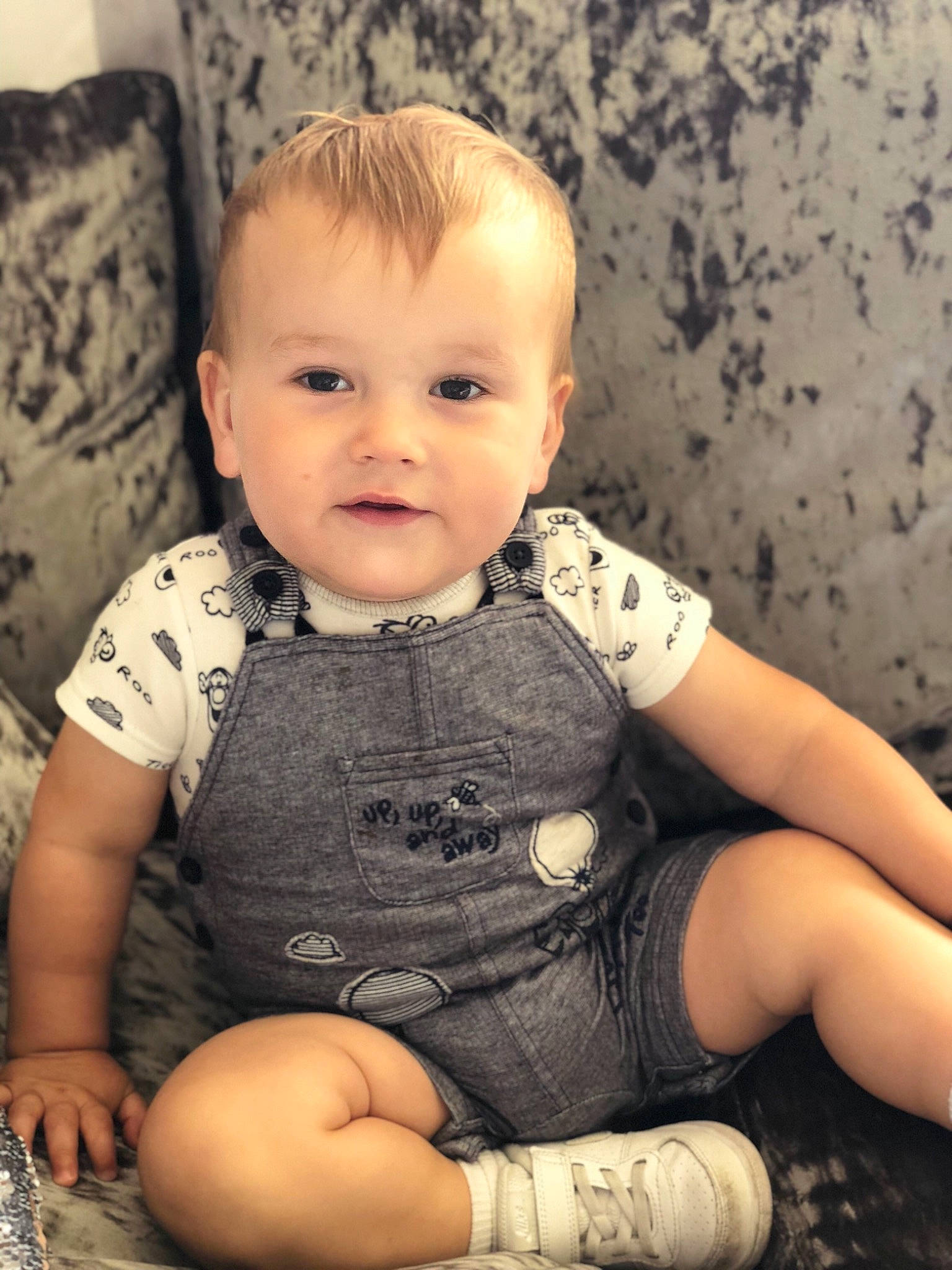 Riley is registered to the contest to win money with this photo: arm, baby, blond, cheek, child, child_model, chin, eye, face, head, iris, leg, nose, person, sitting, skin, smile, toddler