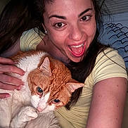Rusty is registered to the contest to win money with this photo: animal, bed, bedroom, blanket, cat, close_up, cuddling, happy, indoor, long_hair, open_mouth, orange_cat, person, pet, portrait, selfie, smiling, white_cat, woman, yellow_shirt