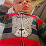 Cassius joined the competition — help win amazing prizes! baby, child, onesie, striped_clothing, bear_design, tongue_out, lying_down, blanket, bed, indoor, cute, infant, playful, cozy, person, young_child, face, expression, soft, warm