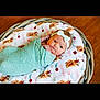 Georgia joined the competition — help win amazing prizes! baby, newborn, swaddled, blanket, headband, bow, basket, floor, wooden_floor, infant, cute, soft, floral_print, animal_print, lying_down, indoors, portrait, child, person, cozy