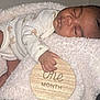 baby, blanket, child, closeup, cozy, cute, face, hand, indoors, infant, newborn, one_month, onesie, peaceful, portrait, resting, sleep, sleeping, soft_texture, wooden_sign
