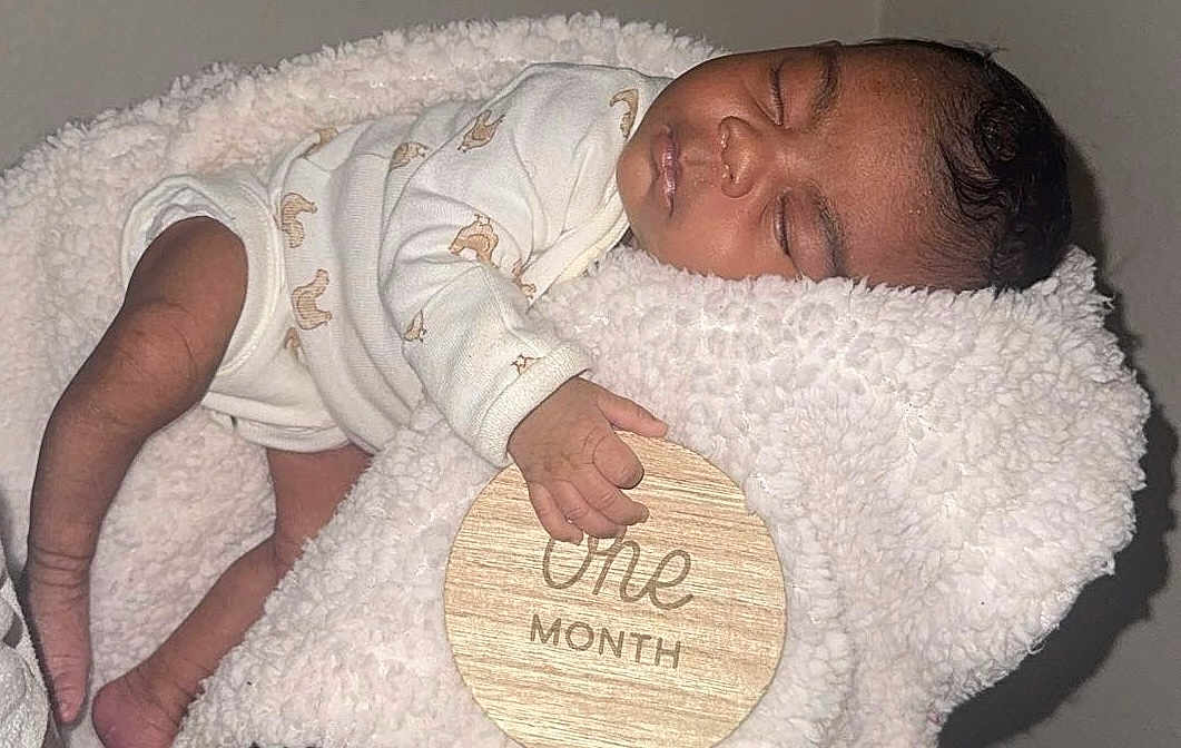 Monay joined the competition — help win amazing prizes! baby, blanket, child, closeup, cozy, cute, face, hand, indoors, infant, newborn, one_month, onesie, peaceful, portrait, resting, sleep, sleeping, soft_texture, wooden_sign