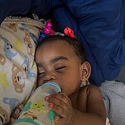 Monay is registered to the contest to win money with this photo: baby, bed, blanket, bottle, child, comfort, cute, face, hair_ties, hand, indoors, infant, milk, pajamas, peaceful, resting, sleeping, soft, toddler, young_child