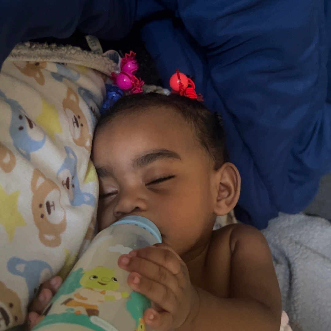 Monay is registered to the contest to win money with this photo: baby, bed, blanket, bottle, child, comfort, cute, face, hair_ties, hand, indoors, infant, milk, pajamas, peaceful, resting, sleeping, soft, toddler, young_child