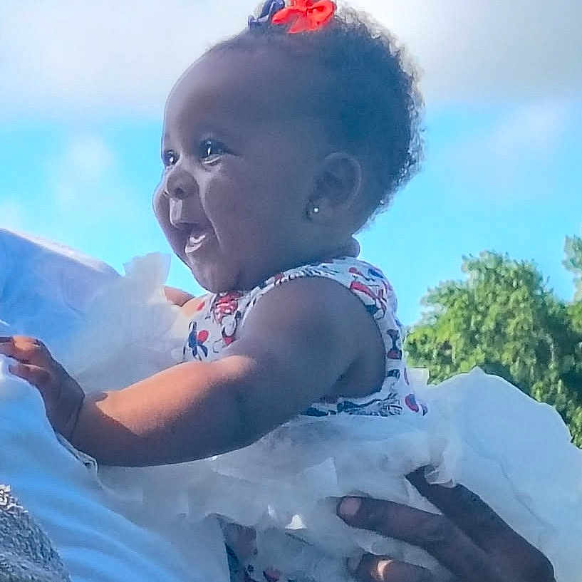 Willow joined the competition — help win amazing prizes! baby, blue_sky, child, cute, dress, face, hair_bow, hands, happy, holding, infant, nature, outdoor, person, portrait, skin, smiling, sunlight, toddler, trees