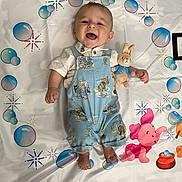 Peter is registered to the contest to win money with this photo: accessories, baby, babylaughing, balloon, bed, clothing, crib, dress, face, furniture, happy, head, infantbed, jeans, laughing, pants, person, photography, portrait, smile