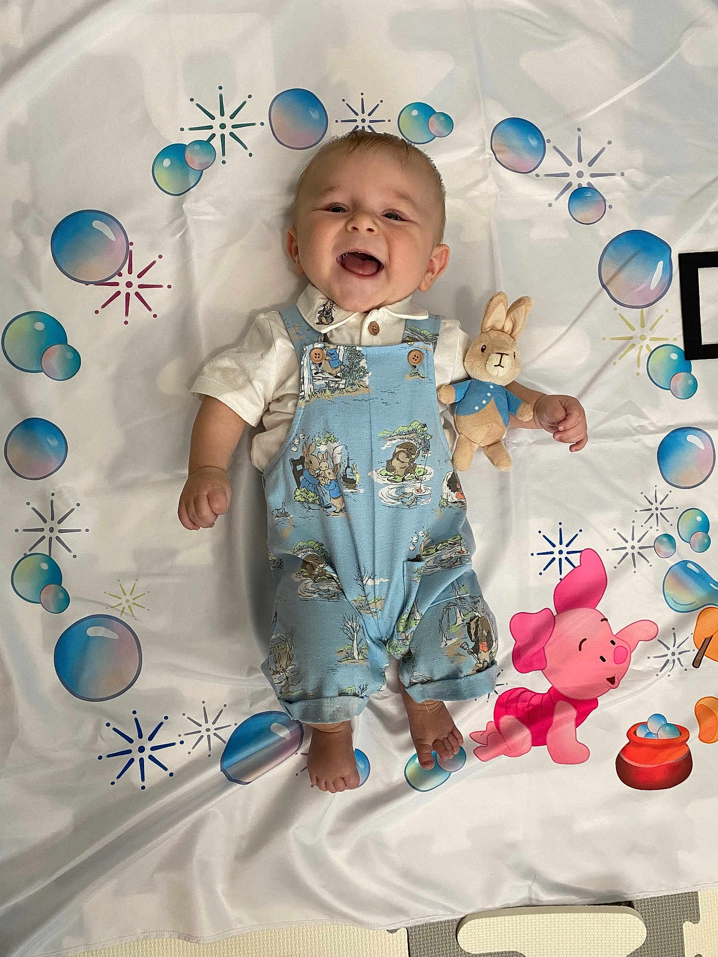 Peter is registered to the contest to win money with this photo: accessories, baby, babylaughing, balloon, bed, clothing, crib, dress, face, furniture, happy, head, infantbed, jeans, laughing, pants, person, photography, portrait, smile