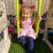 Maria joined the competition — help win amazing prizes! child, girl, swing, playground, outdoor, sunlight, pink_bows, pigtails, pink_skirt, blue_tights, smiling, grass, fence, toy, playhouse, happy, daytime, cute, childhood, recreation