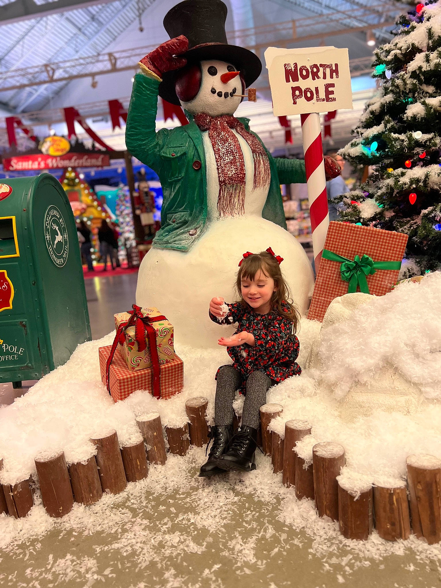 Ariel is registered to the contest to win money with this photo: boot, child, christmas_decoration, christmas_tree, conifer, event, fictional_character, freezing, fun, green, hat, holiday, joy, person, recreation, santa_claus, snow, snowman, standing, toddler