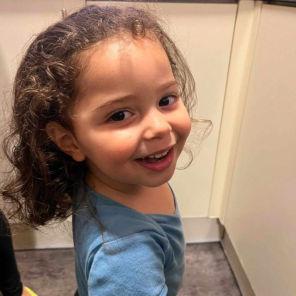 Samael is registered to the contest to win money with this photo: blue_shirt, cabinet, casual, child, curly_hair, expression, face, floor, foot, happy, indoor, kitchen, light, person, portrait, smiling, socks, standing, young