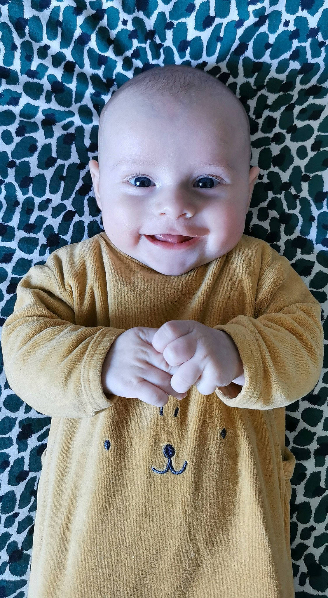 Noa participe au concours pour gagner de l'argent avec cette photo : baby, baby_toddler_clothing, cheek, collar, eye, face, gesture, grey, happy, joy, linens, lip, organ, outerwear, pattern, person, product, skin, sleeve, smile