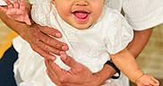 Diana joined the competition — help win amazing prizes! adult_hands, baby, bows, child, close_up, cute, fashion, happy, holding, indoor, infant, joyful, person, playful, portrait, smiling, tongue_out, waving_hand, white_dress, white_shirt