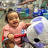 Diana joined the competition — help win amazing prizes! aisle, baby, child, cute, expression, grocery, happy, holding, indoor, infant, person, pink_clothing, plush_toy, retail, shopping_cart, smiling, store, toy, warehouse, white_socks