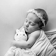 Mia a rejoint le concours — aidez-le/la à gagner de superbes lots ! baby, sleeping, black_and_white, blanket, plush_toy, headband, flower, cute, peaceful, infant, portrait, soft_texture, child, adorable, wrapped, tender, face, closed_eyes, resting, newborn