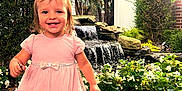 Melody joined the competition — help win amazing prizes! bow, child, cute, daylight, flowers, garden, girl, greenery, happy, nature, outdoor, pavement, pink_dress, plants, playful, portrait, smiling, toddler, walking, waterfall