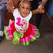 Neriah-Meriah is registered to the contest to win money with this photo: toddler, child, birthday, smile, happy, colorful_clothing, bow, hands, indoor, floor, person, celebration, cute, playful, family, holding_hands, sitting, white_shirt, skirt, headband