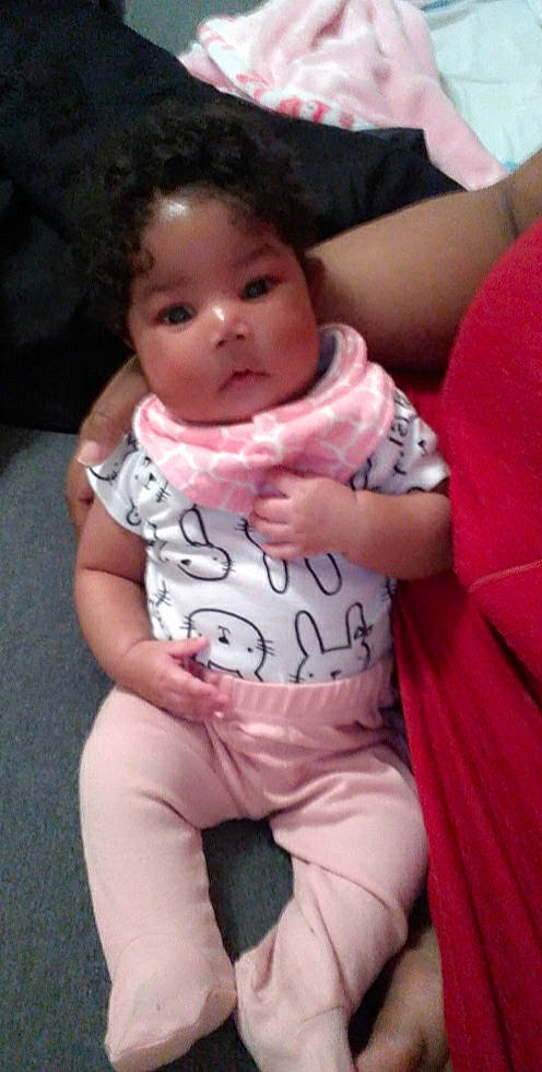 Kaycee is registered to the contest to win money with this photo: baby, baby_toddler_clothing, cheek, chest, comfort, finger, gesture, grass, happy, lip, mouth, nose, person, pink, skin, sleeve, smile, t_shirt, thumb, toddler