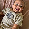 baby, child, infant, smiling, happy, portrait, face, eyes, mouth, lying_down, bed, bedsheet, pink, onesie, clothing, elephant, toy_design, indoor, close_up, photography