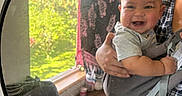 Roman joined the competition — help win amazing prizes! baby, infant, child, smiling, happy, portrait, mirror, reflection, adult, parent, holding, indoor, window, greenery, plaid, clothing, carrier, seated, home, photography
