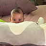 Roman is registered to the contest to win money with this photo: baby, infant, child, face, eyes, peeking, blanket, bed, pillow, bedroom, indoor, portrait, curious, cozy, soft_furnishings, bedding, white_blanket, pink_pillow, sitting, home