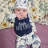 Layne joined the competition — help win amazing prizes! baby, baby_hat, bed, child, cute, eyes, face, feet, floral_blanket, hands, indoors, infant, little_brother, lying_down, nursery, pacifier, patterned_clothing, pink_bedding, portrait, smiling
