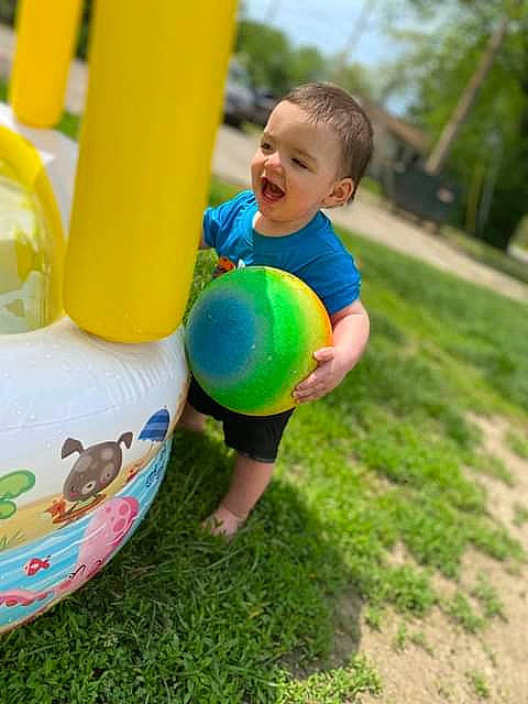 Aiden is registered to the contest to win money with this photo: ball, child, electric_blue, fun, games, grass, happy, leisure, outdoor_play_equipment, party_supply, people_in_nature, person, plant, playground, public_space, recreation, shorts, t_shirt, toddler, tree