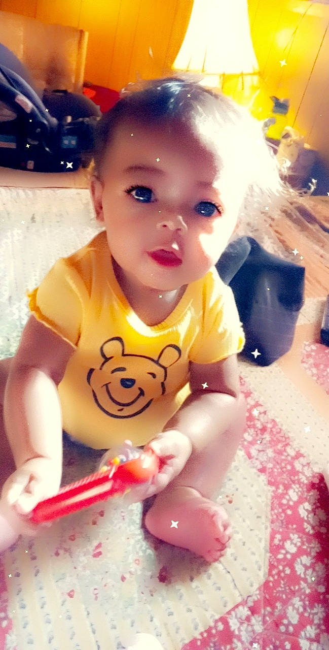 Amoura is registered to the contest to win money with this photo: baby, baby_toddler_clothing, cheek, chin, cool, face, facial_expression, finger, flooring, fun, happy, head, lip, mouth, nose, person, pink, skin, standing, toddler