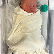 Zander is registered to the contest to win money with this photo: newborn, baby, swaddled, blanket, infant, sleeping, hospital, bassinet, pacifier, soft, white, peaceful, wrapped, resting, cute, portrait, child, toddler, young, cozy