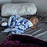 baby, child, blanket, bed, pillow, indoor, sleepwear, resting, curious, cozy, soft, gaze, lying_down, fabric, comfort, person, infant, room, home, casual