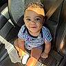 toddler, child, car_seat, seatbelt, smile, sunlight, shadow, curly_hair, clothing, sock, leather_seat, happy, portrait, baby, sitting, indoor, person, cute, safety, bright