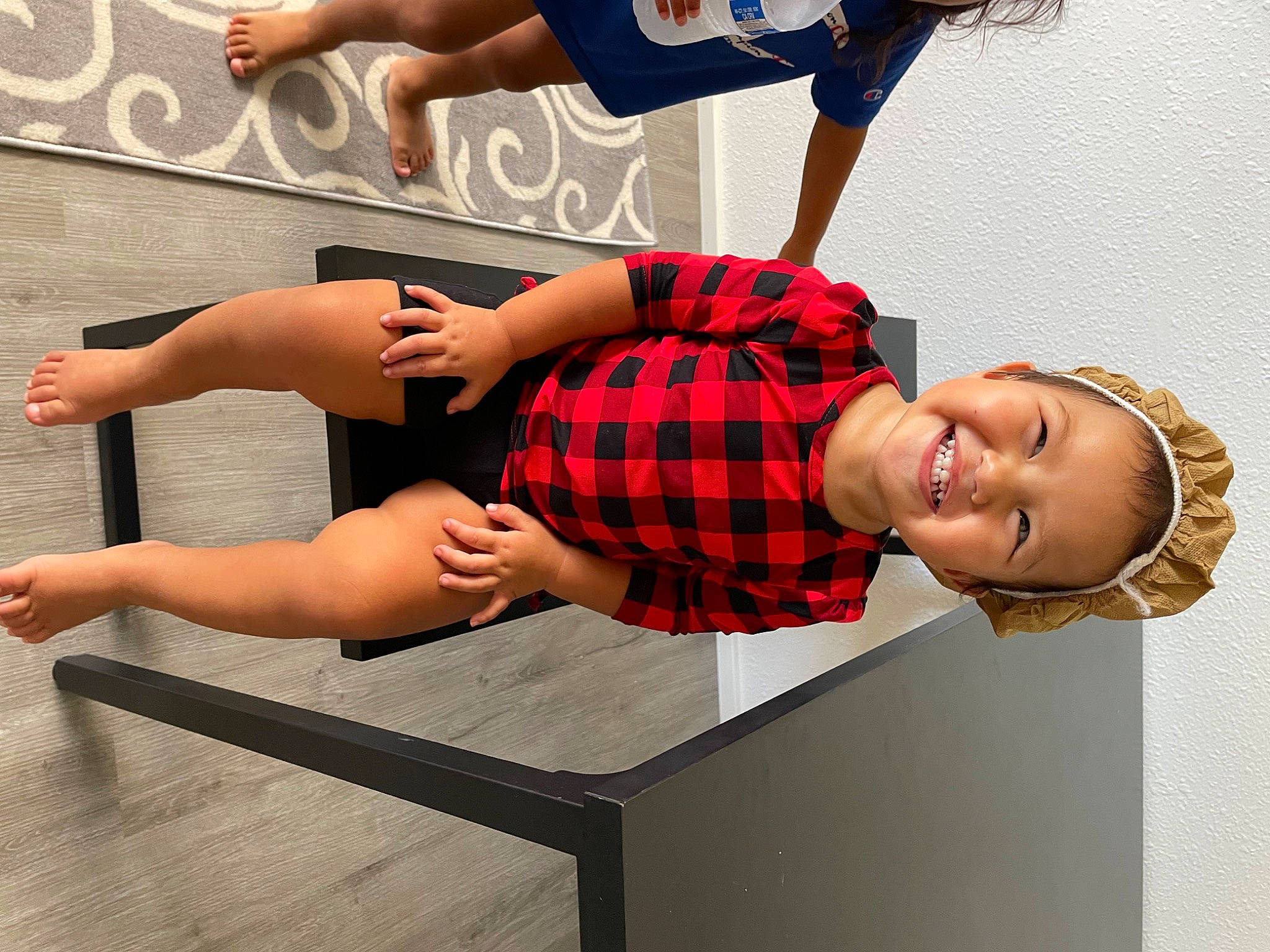 Azariah is registered to the contest to win money with this photo: arm, comfort, dress, elbow, eyewear, fun, gesture, human_leg, joint, joy, knee, leg, muscle, person, plaid, red, shorts, smile, table, tartan