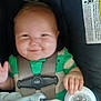 baby, child, car_seat, smile, pacifier, green_shirt, seatbelt, infant, hand, blanket, happy, cute, face, person, safety, car, transportation, child_seat, baby_toys, clothing