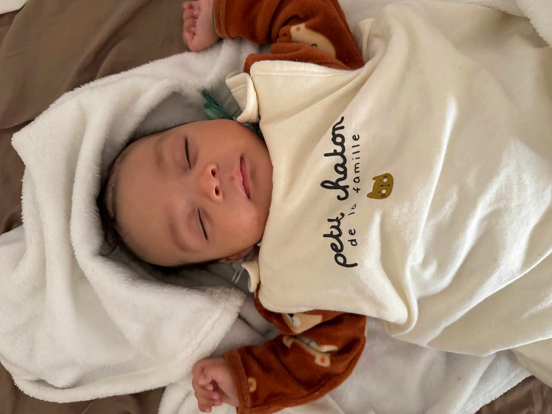 Aïden a rejoint le concours — aidez-le/la à gagner de superbes lots ! baby, sleeping, blanket, brown_clothing, cute, infant, face, peaceful, soft, cozy, child, portrait, resting, small_hands, indoors, comfortable, toddler, cute_outfit, warm, nap