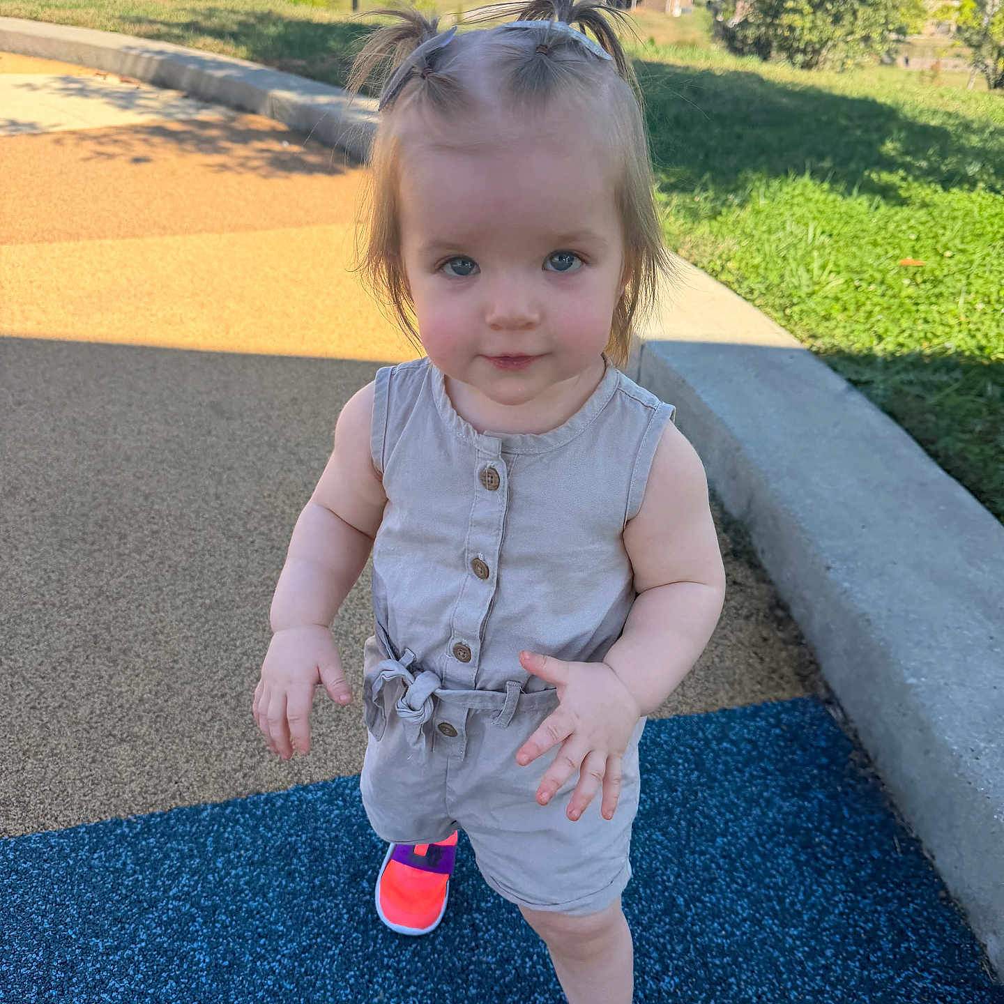Remie joined the competition — help win amazing prizes! toddler, child, girl, standing, portrait, pigtails, smiling, playground, outdoor, sunny, romper, overalls, buttons, neon_shoes, sneakers, suburban, sidewalk, grass, residential, daylight