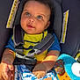 baby, car_seat, blue_eyes, yellow_shirt, blue_shorts, plush_toy, sunlight, safety_harness, child, infant, cute, smiling, curly_hair, seat_belt, colorful, indoor, portrait, happy, skin, clothing