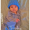 baby, infant, blue_hat, pom_pom, pajamas, bed, bedding, blanket, lying_down, portrait, cute, child, face, skin, sleepwear, indoors, soft_lighting, time_stamp, watermark, calm