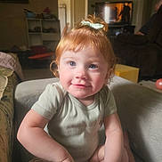 Nova joined the competition — help win amazing prizes! toddler, child, red_hair, bow, smile, indoor, living_room, couch, furniture, television, curly_hair, person, cute, young_child, casual_clothing, home, seated, portrait, happy, baby