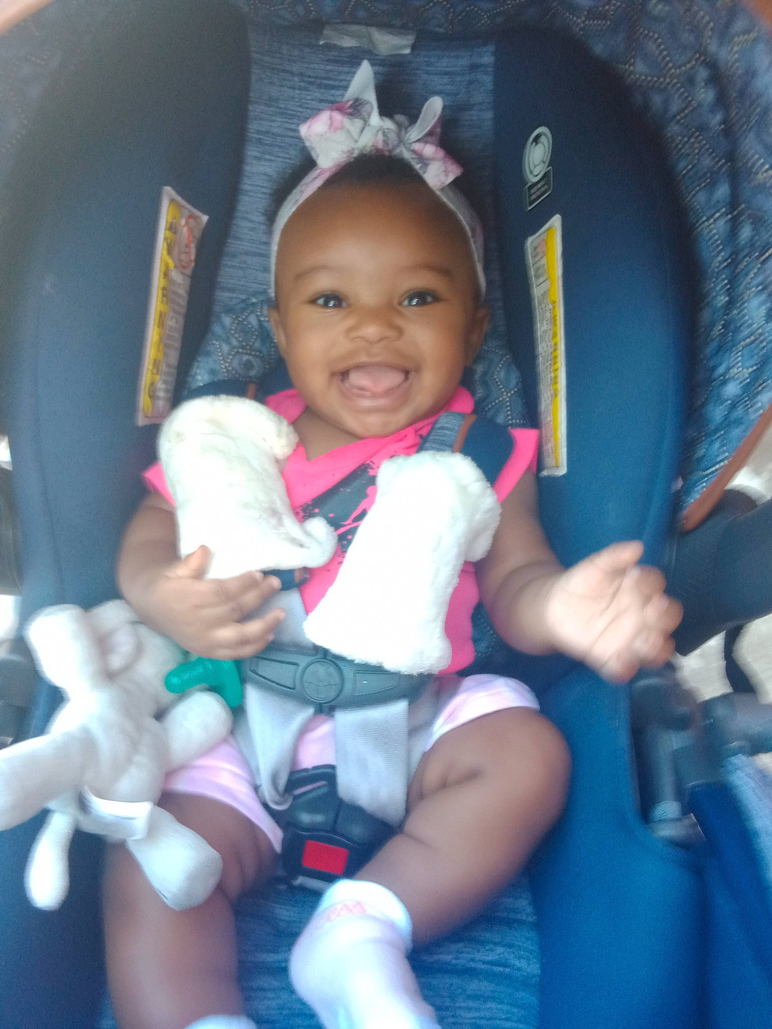 Tory is registered to the contest to win money with this photo: azure, blue, car_seat, chair, comfort, finger, fun, happy, joy, lap, leg, mammal, person, pink, product, purple, skin, smile, thigh, toddler