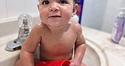 Zaylen is registered to the contest to win money with this photo: baby, child, toddler, bathtub, bathroom, water, wet, sitting, smiling, face, portrait, red_cup, bath_toy, bottle, skincare, faucet, tiles, indoor, bathing, happy