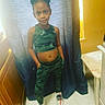 Mia is registered to the contest to win money with this photo: boy, child, clothing, face, footwear, head, indoors, jeans, male, navel, pants, person, photography, plywood, portrait, sandal, shoe, shorts, sitting, wood