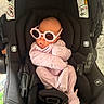 baby, infant, car_seat, sunglasses, pink_clothing, cute, newborn, child, seatbelt, indoor, accessory, pout, fashion, headwear, soft_lighting, portrait, baby_clothes, resting, baby_girl, adorable