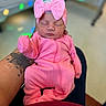 newborn, baby, pink_outfit, headband, bow, sleeping, tattoo, arm, person, infant, indoor, closeup, soft_lighting, caring, holding, portrait, cute, peaceful, child, newborn_clothing