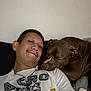 Kash joined the competition — help win amazing prizes! man, dog, selfie, smile, pet, friendship, indoor, casual, resting, comfort, animal, portrait, brown_dog, human, tshirt, necklace, nap, closeup, couch, relaxation